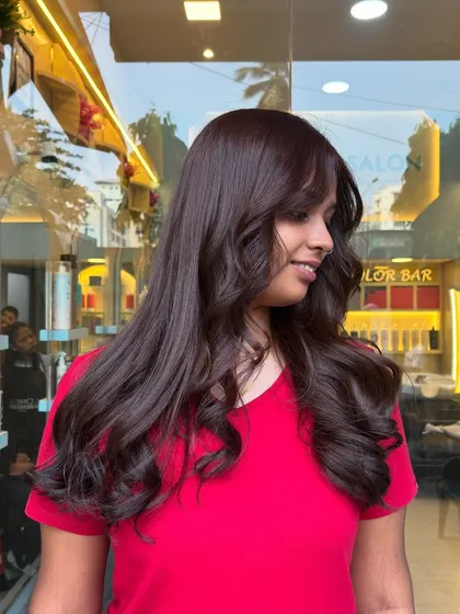 A happy client showing off her transformation. Her hair looks healthier, shinier, and full of life after her salon visit.