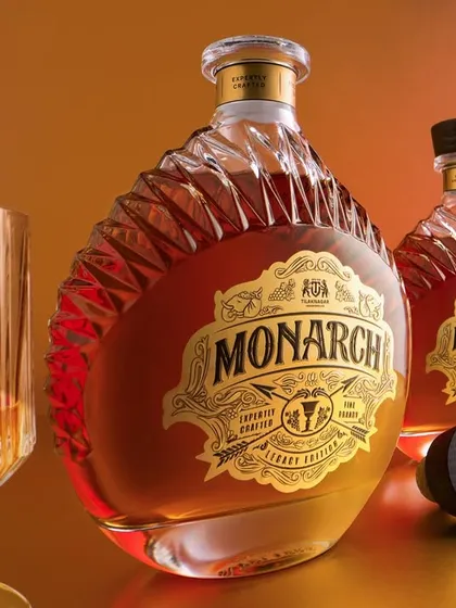 A classic product shot of the Monarch range. The warm, gradient background and soft lighting make the golden liquid and intricate labels glow. This type of shot is perfect for showcasing the full bottle and its smaller counterpart.