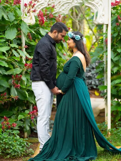 An intimate couple's portrait in a beautiful garden archway. The lush flowers and greenery create a romantic and secluded feel.