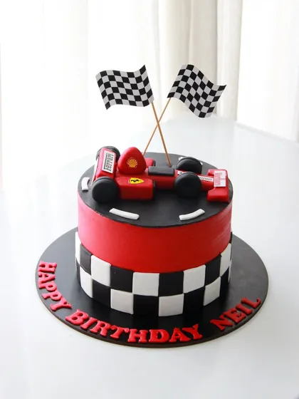 A full view of the race car cake for Neil's birthday, complete with checkered flags to celebrate his victory lap.