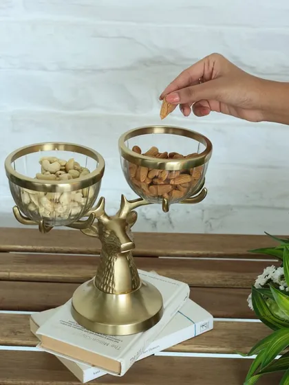 Our golden reindeer stand, shown here holding glass bowls filled with nuts. It's a functional work of art, designed to bring a touch of enchantment to your hosting essentials.
