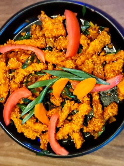 This is chicken sesame, prepared in an Assamese style. The chicken is coated in a nutty sesame paste, giving it a rich and distinct flavour profile.