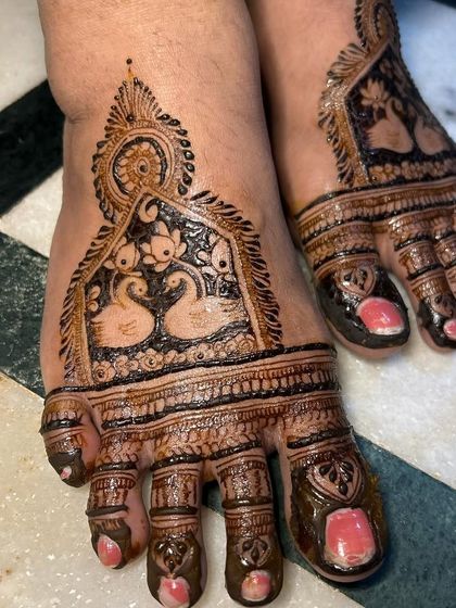 A close up of the swan design on the feet. You can see the fine details and shading that bring the birds to life within the henna pattern.