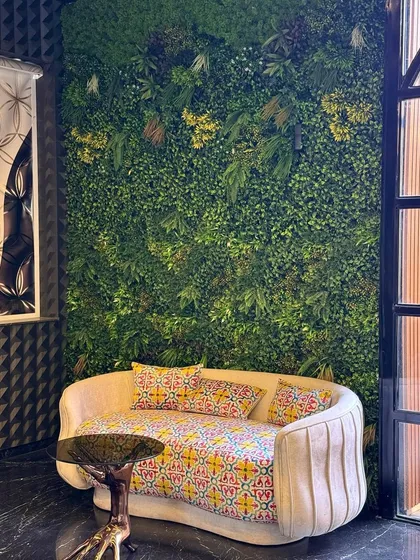 A perfect blend of comfort and nature. The artificial green wall in this sitting area adds a calming, organic element that enhances the room's decor without requiring any maintenance.