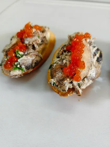 Layers of indulgence on a crisp crostini. Earthy truffle-kissed mushrooms in rich cream, crowned with glistening caviar pearls and fresh parsley for a bite of pure luxury.
