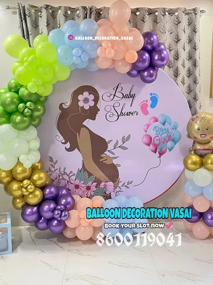 A colorful and modern baby shower design with a rainbow-hued balloon arch. The custom backdrop features a silhouette of a mother-to-be, making it a very personal and touching centerpiece.