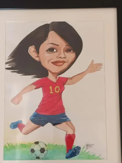 Here is a finished, framed caricature of the female football player. The professional framing elevates the artwork and makes it a perfect gift.