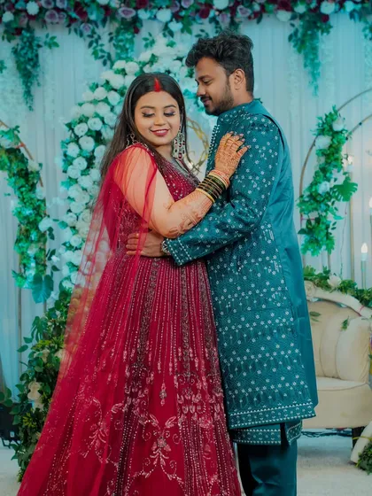 Capturing the romance on the dance floor. This full-length shot shows the couple in a sweet embrace during their reception, surrounded by elegant floral decor.