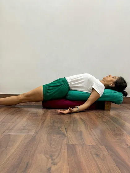 A supported Purvottanasana using bolsters and blocks. This setup is excellent for restorative practice, as it fully supports the spine and allows the chest to open passively, promoting relaxation and gentle strengthening.
