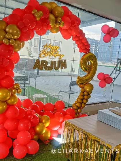 A bold red and gold balloon ring for Arjun's 9th birthday, creating a vibrant and celebratory photo spot.