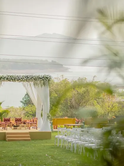A beautifully framed shot of the empty wedding mandap by the lake, setting the scene for the ceremony to come.