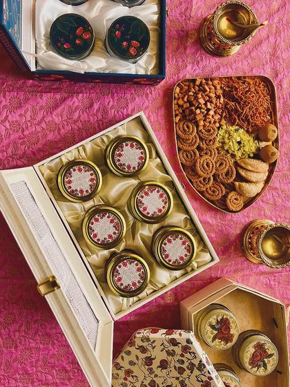 A flat lay of our Diwali hampers, showcasing the premium boxes and delicious, traditional homemade snacks like chakli, shev, and ladoo.