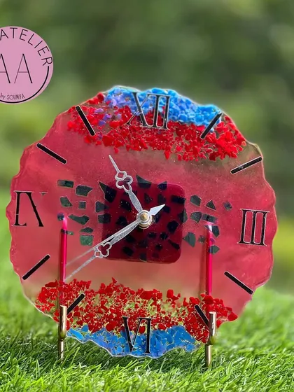 A vibrant and unique resin table clock with red and blue crystals, perfect for adding a pop of color to your decor.