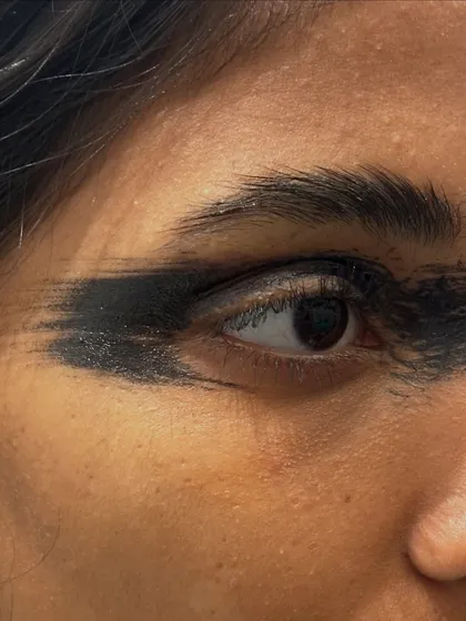 A close-up of a bold, smudged eyeliner look paired with strong soap brows. This is a raw, edgy style perfect for fashion-forward editorials.