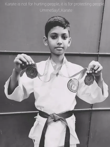 "Karate is not for hurting people, it is for protecting people." This student, holding his tournament medals, understands the true meaning of martial arts.