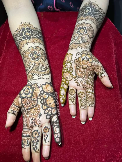 A full-coverage Indo-Arabic design with large, bold floral patterns that flow from the arm down to the fingers.