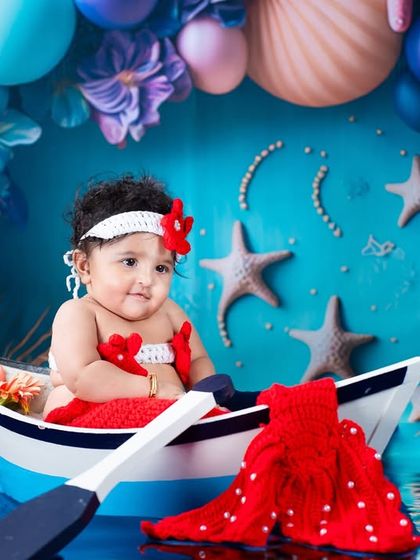 A little mermaid enjoying a boat ride in a magical sea. The vibrant blue and purple tones and underwater props create a stunning visual story.