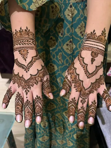 A graceful and light design for the back of the hands. This pattern has a jewelry-like feel, with a central motif and patterns that flow down the fingers.