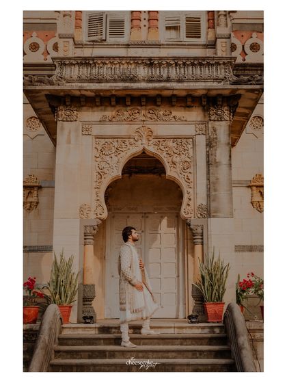 A stylish portrait of the groom on the palace steps.