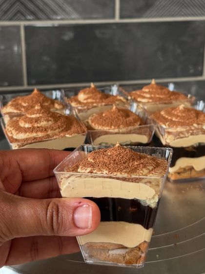 A single Tiramisu mousse cup, showing the distinct layers of coffee-soaked biscuit and creamy mousse.