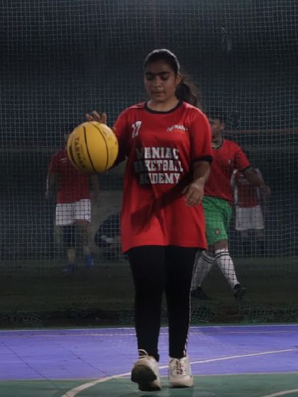 A female player confidently handles the ball. Our academy is a place where girls develop their skills and become key players on the court.