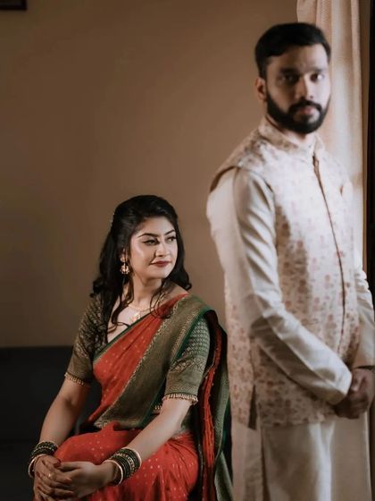 An artistic portrait capturing a candid moment. The groom looks out the window while the bride watches him, telling a story without words.