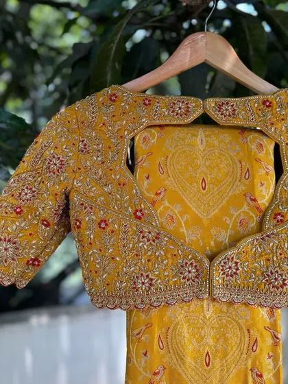 I designed this statement blouse with a unique heart-shaped cut-out back. The entire piece is covered in dense floral hand embroidery, making it a romantic and eye-catching choice for a bride.