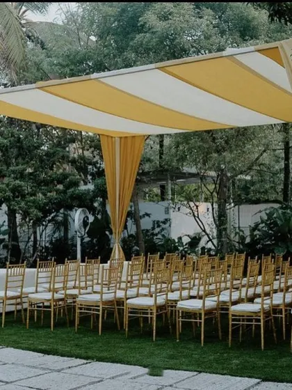 This image shows the guest seating area for a modern Haldi. The yellow and white striped canopy provides shade and adds a chic, cabana-like feel to the outdoor event, ensuring guests are comfortable and stylishly accommodated.