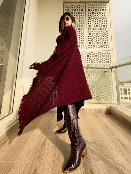 A shot showing the movement of the fringed poncho. The texture and flow of the fabric are key elements of this look.