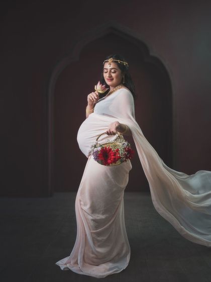 Serene bloom. This enchanting maternity shoot embodies Indian beauty, with an elegant dhoti-style saree and delicate lotus flowers.