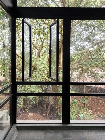 Windows at 'Villa 16' open directly into the grove, blurring the line between inside and out. The house is designed to breathe with the forest.