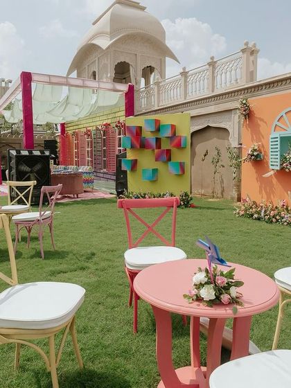 A wide view of the carnival Mehendi setup, with brightly colored seating and fun photo walls set against the grand architecture of the venue.