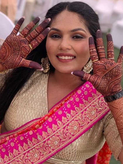 A happy bride showing off her beautiful mehndi. Her smile and the rich color of the henna are what make my job so fulfilling.