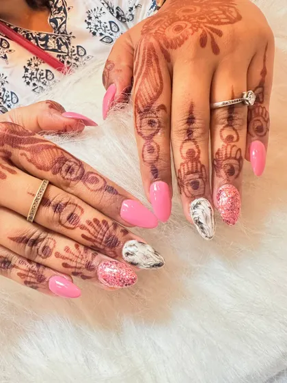 A fun and glamorous set for a party or wedding event. This look combines bright pink nails with accent nails featuring a black and white marble effect and pink glitter.