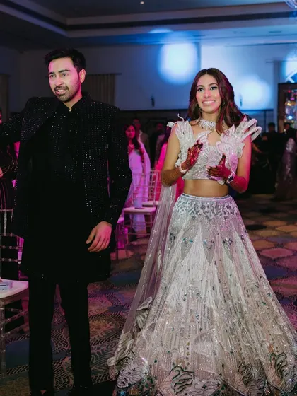 The couple making their entrance at the Sangeet. Her unique outfit and glamorous makeup make her stand out.