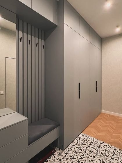 This image shows a complete entryway solution, combining a full-height wardrobe with a foyer unit. The unit includes a comfortable seating bench, coat hooks, and a mirror, making it a practical and welcoming feature.