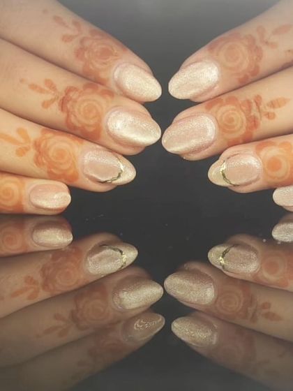 A full view of the sophisticated shimmery nude nails, showing how they beautifully complement the traditional henna art.