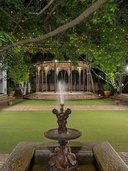The Colonial Bandstand and lawn lit up for a night event, showing the venue's capacity for large, elegant receptions.