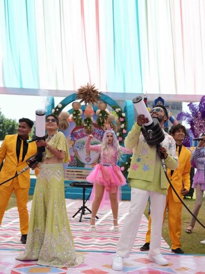 The bride and groom, armed with CO2 guns, lead the party from the front. This is what a high-energy carnival looks like.