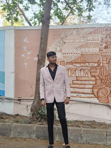 A client looking sharp in a light pink blazer paired with black trousers. This is a modern and stylish combination for farewell parties or reception events.