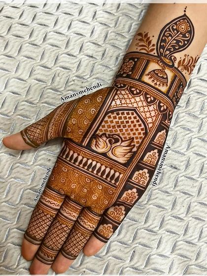 A classic design with a pair of swans in the center of the palm. The wrist is adorned with a jhumka and a peacock feather, adding to the traditional charm.