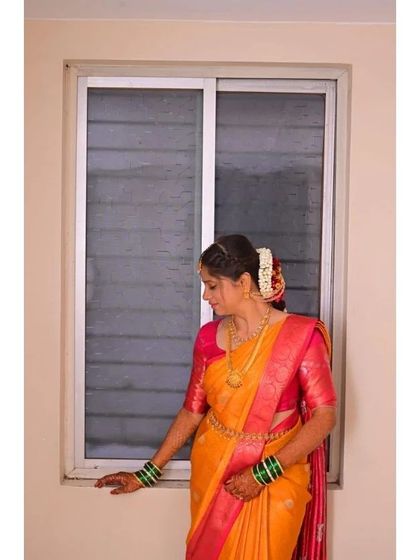 A side profile of a traditional bride, showing how the hairstyle with fresh flowers and makeup come together. The look is soft and elegant, perfect for a daytime wedding ceremony.
