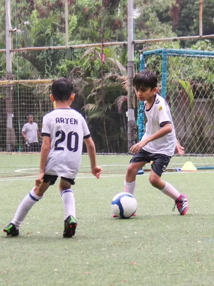 A player looks to dribble past his teammate, whose jersey number is 20, during a competitive practice game.