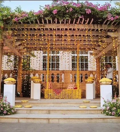 For this resort Haldi, I designed a beautiful setup under a bougainvillea-laden pergola. A jhoola decorated with marigolds served as the centerpiece, with hanging flower strings adding to the festive feel.