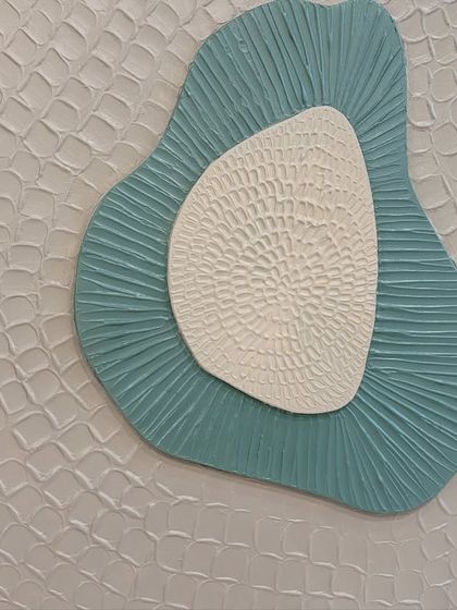 Detail of the outer layer of one of the sculptural pieces, showing a repeating, almost scale-like pattern that adds another layer of complexity to the design.