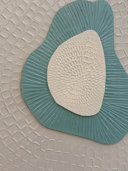 Detail of the outer layer of one of the sculptural pieces, showing a repeating, almost scale-like pattern that adds another layer of complexity to the design.