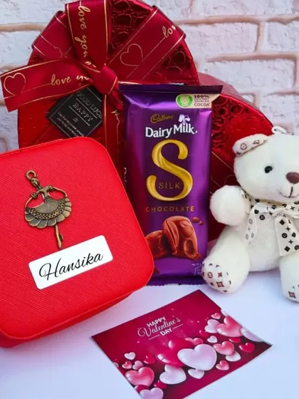 A lovely Valentine's gift for her. This set includes a personalized jewelry box with a ballerina charm, a teddy bear, a Dairy Milk Silk, and a Valentine's card.