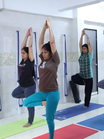An instructor guides students in Vrikshasana (Tree Pose) during our free offline yoga camp. This balancing pose helps to improve focus, concentration, and physical stability.