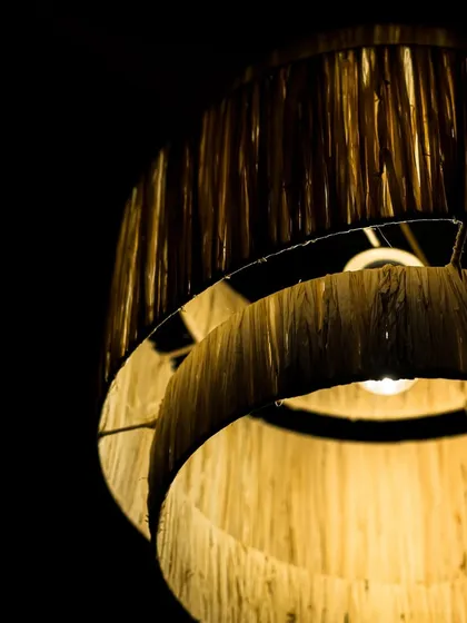 A close look at the texture of my tiered natural fiber lampshade. You can see the individual strands and the slight variations that are the hallmark of a truly handmade object, giving it a depth that mass-produced items lack.
