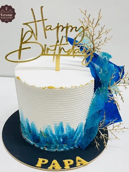 A mango pista cake with a modern blue brushstroke design. The abstract art style is complemented by gold accents and a "Happy Birthday Papa" topper.